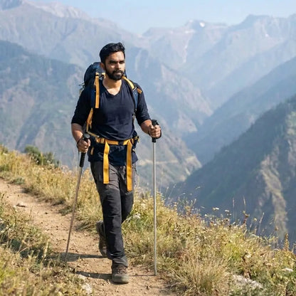 Man hiking with trekking poles and a backpack in a mountainous landscape